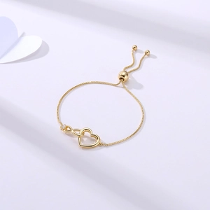 Close-up of golden infinity heart bracelet with cubic zirconia and adjustable chain