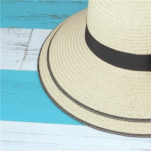 Vue détaillée du tissage mécanique de la paille et du ruban noir sur le chapeau de soleil