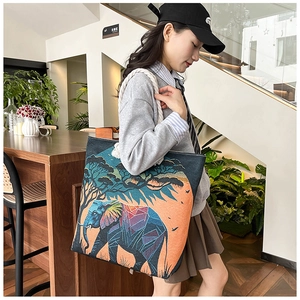 Detailed close-up of elephant embroidery and woven rope handles on a canvas tote bag