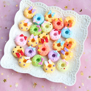 Macro shot of colorful matte resin bow donuts on a tray for DIY craft and phone case decor