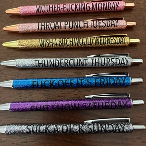 Detailed view of 7 glittery ballpoint pens for each day of the week with bold text