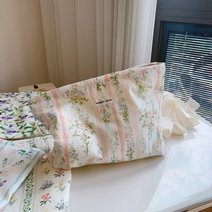 Close-up of floral cotton cosmetic bag with zipper and Simple Wish label on white table