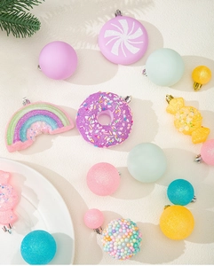 Detail of macaron-colored Christmas ornaments including donuts and rainbow hanging pendants