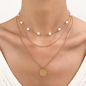 Three-layer gold necklace set featuring round pearls and a minimalist circular coin pendant
