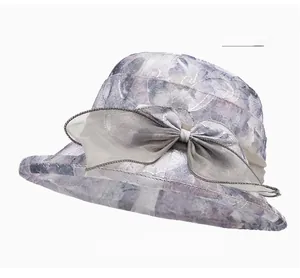 Close-up of translucent organza sun hat featuring an elegant grey bow and ruffled brim