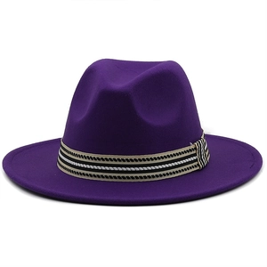 Dettaglio cappello in lana viola con nastro a righe bianche e nere dallo stile elegante