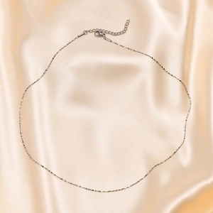 Silver stainless steel snake chain necklace on silk background with lobster clasp detail