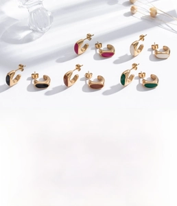 Détail macro des boucles d'oreilles rétro en C en acier titane avec zircon incrusté