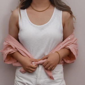 Lifestyle shot of model wearing 18K gold-plated necklace, bracelet and ring set