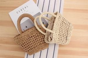Detailed view of woven straw handbags in brown and cream colors for beach vacations