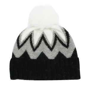 Détail du bonnet en tricot avec motif jacquard en zigzag et grand pompon blanc en fausse fourrure