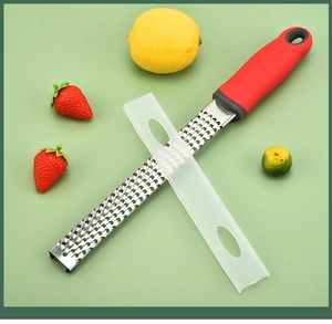 Close-up of stainless steel kitchen grater with red handle and protective cover