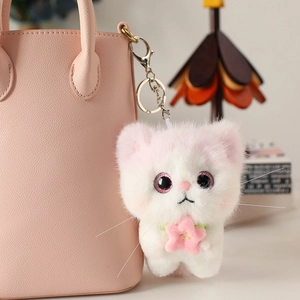 Cute white plush angel cat keychain with pink cherry blossom on a leather handbag