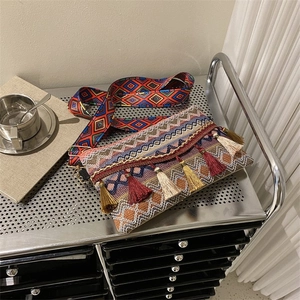 Detail of bohemian weave bag featuring vibrant geometric patterns and long colorful tassels