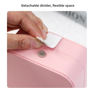Detail of pink jewelry box featuring a magnetic metal clasp and a removable leather divider