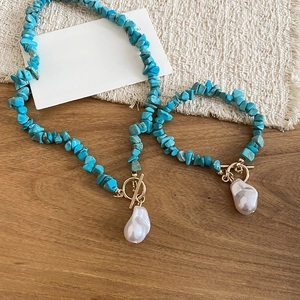Detailed view of turquoise bead and pearl jewelry set with golden toggle clasp