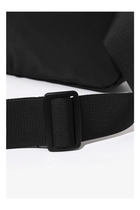 Detailed close-up of the adjustable nylon strap and matte plastic buckle on this waist bag