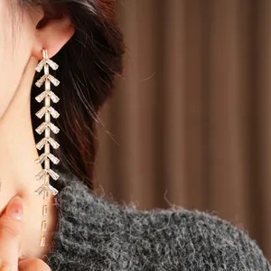 Luxurious gold leaf tassel earrings with sparkling cubic zirconia on a female model
