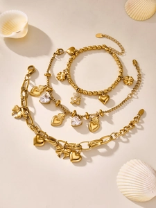 Detailed macro of gold stainless steel bracelet set with heart, bear and zircon charms