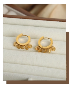 Gros plan de boucles d'oreilles dorées en U avec pendentifs rayés sur velours