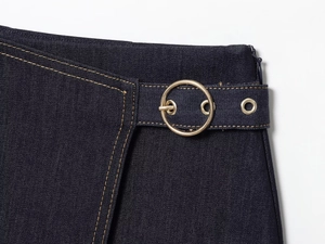 Détail de la taille en denim bleu foncé avec boucle dorée et surpiqûres contrastées