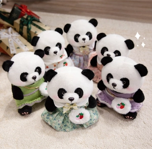 Nahaufnahme süßer Panda-Stofftiere in bunten Strickkleidern und kleinen Accessoires