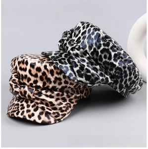 Detail showing leopard print texture and bow knot on leather flat top newsboy caps