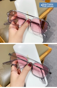 Detail of grey frame sunglasses with pink gradient lenses and metal temple accents