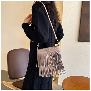 Close-up of khaki tassel crossbody bag with suede texture and metal buckle detail