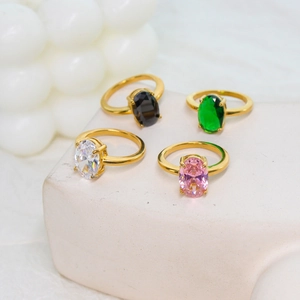 Elegant 18K gold plated oval cut gemstone rings in four colors on a white stone base