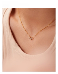 Detail showing an 18k gold plated titanium necklace with three sparkling zircons on a collarbone