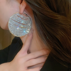 Close-up of sparkling oversized geometric round earrings with s925 silver needles