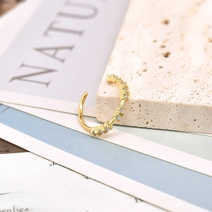 Macro shot of an 18k gold geometric ear cuff with micro-pave white zircon stones
