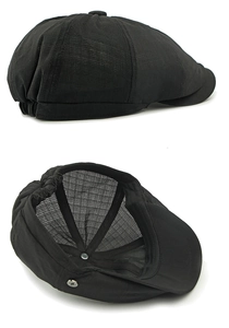Detail of black breathable newsboy cap with elastic back and silver decorative button