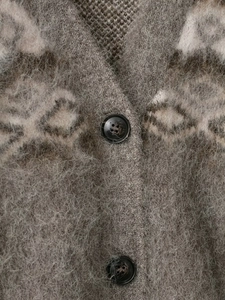 Close-up of geometric jacquard knit cardigan with fuzzy mohair texture and resin buttons