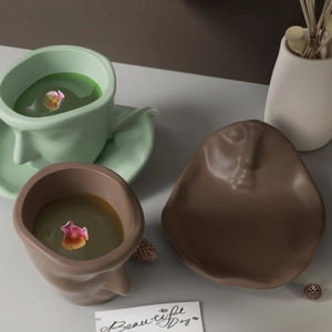 Artistic face relief ceramic coffee cup and irregular saucer set in matte finish