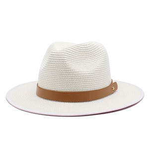 Close-up of woven straw fedora hat texture with brown leather band and golden stud