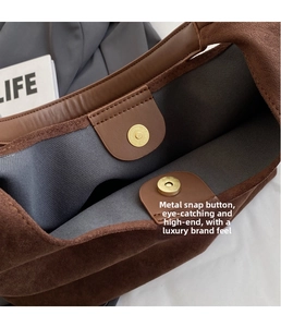 Detailed view of the dark brown suede tote bag featuring gold magnetic closures and lining