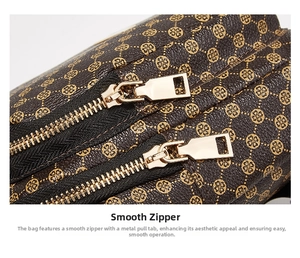Detail of smooth gold metal zippers on a brown crossbody bag with clover pattern