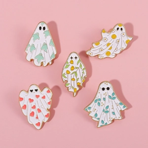Set of five cute white ghost enamel pins with gold metal trim on pink background