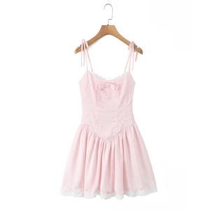Détail de la mini-robe rose avec dentelle délicate et un joli nœud sur la poitrine