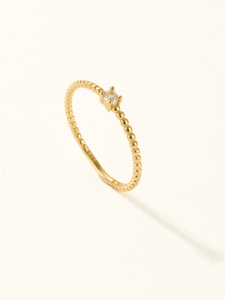 Detail of gold-plated bead band ring featuring a sparkling claw-set cubic zirconia stone