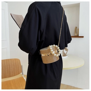 Rear view of mini champagne gold bucket bag with pearls and rhinestones on model