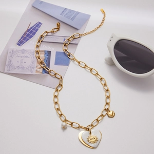 Flat lay of 18K gold stainless steel heart pendant necklace with pearl and sun eye detail