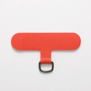 Macro detail of orange fabric phone lanyard tether tab with a sturdy metal D-ring