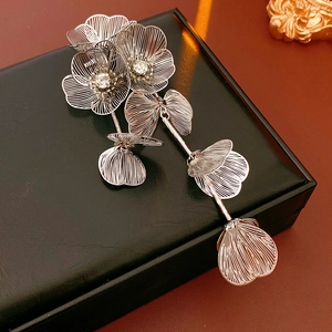 Detail of silver mesh flower brooch with sparkling rhinestones and long tassels