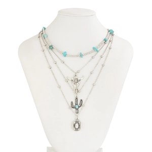 Detail of bohemian layered necklace with turquoise beads, cow skull and cactus charms