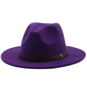 Detail of dark purple wool fedora hat with a woven brown band and metal badge