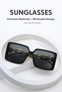 Close-up of square sunglasses with premium gold metal chain temples and black frame