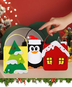 Vue détaillée de trois sacs cadeaux de Noël en feutre avec motifs père Noël et manchot